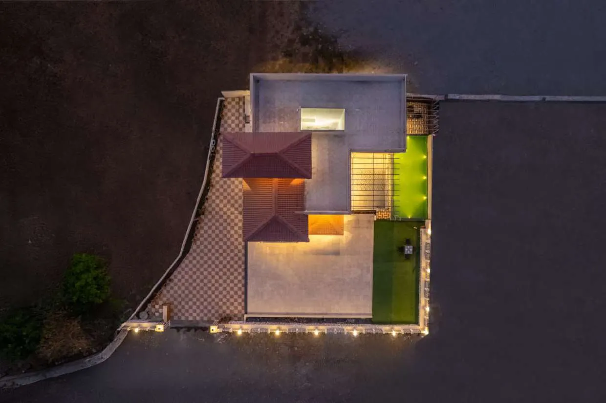 Shuubh Kaustubh 5BHK Villa and its pool and lawn seen from above at dusk